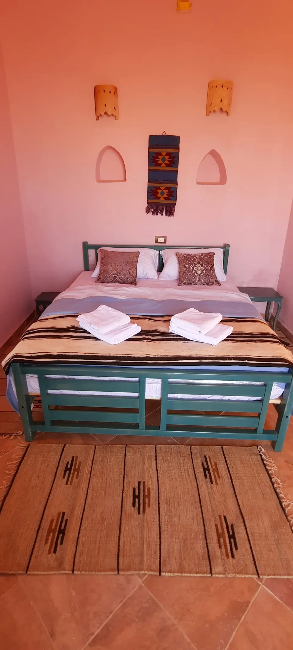 A bed and warm wall colours · Suite