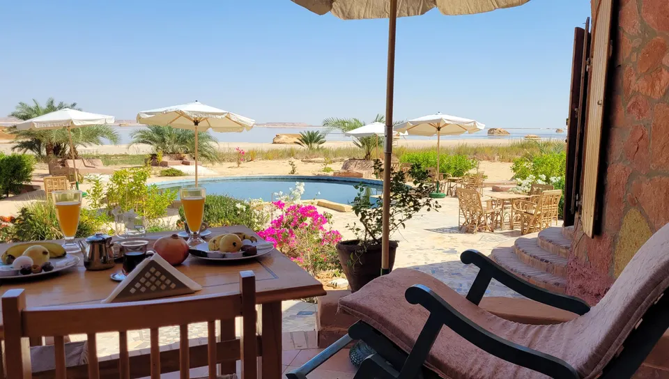 A breakfast table on the terrace overlooking the garden and lake · Suite
