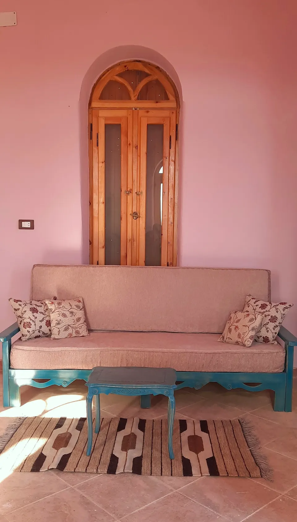 A seating corner beneath an arched window · Suite
