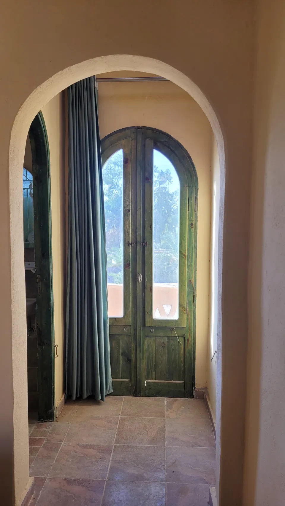 A tall arched window and painted wooden door · Standard