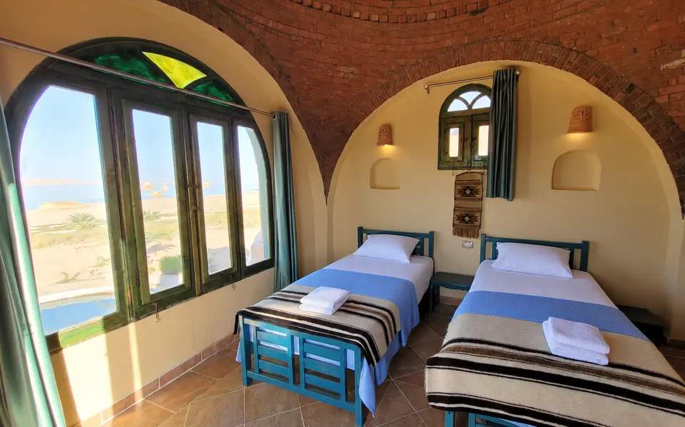 Beds beside large arched windows · Panorama