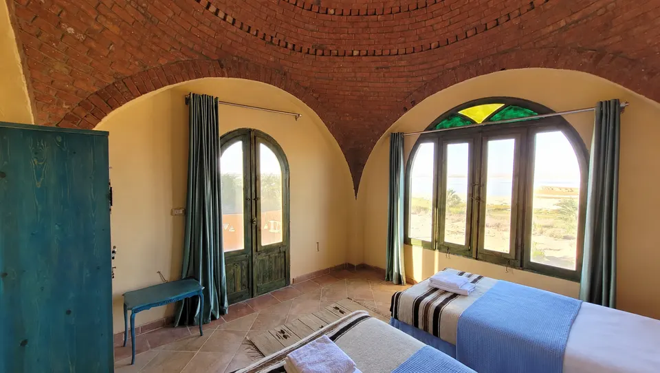 The beds, window and painted wooden door · Panorama