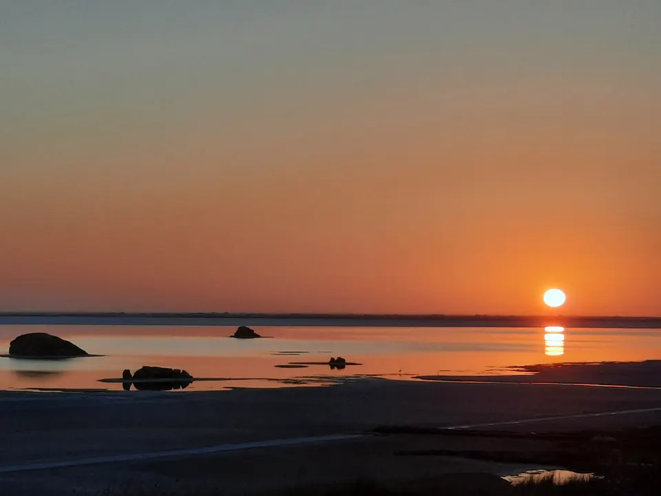 The sun low over the lake and its small islands